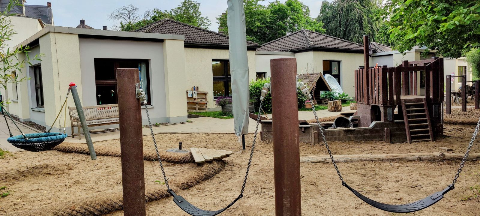 Außengelände des Kindergartens mit Wandbemalung und Wimpeln